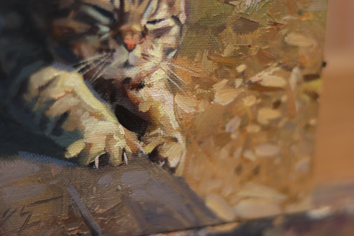 Oil painting of a tabby cat stretching in warm sunlight, with eyes closed and front paws extended. The artwork features expressive brushstrokes and rich textures in tones of gold, brown, and ochre. Canvas size is 6x6 inches.